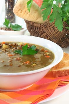 a bowl of lentil soup with bacon and parsley
