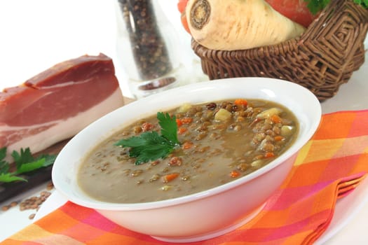 a bowl of lentil soup with bacon and parsley