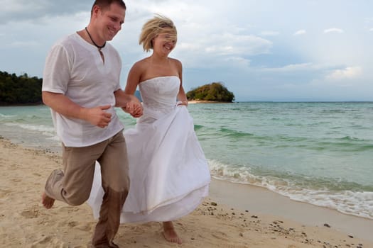 Running on the beach,couple in love on their honeymoon by the sea