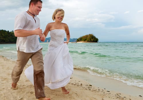 Running on the beach,couple in love on their honeymoon by the sea