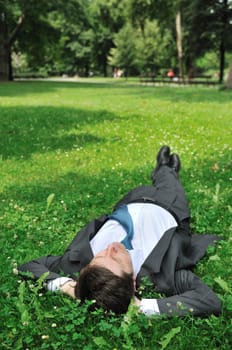 Senior people series - mature business man lying on grass and relaxing in park