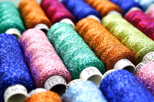 Set of coloured bobbins of lurex thread
