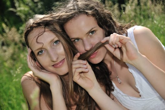 Two happy teenage friends holding hair - pleasure time