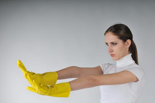Young woman stretching hands with yellow gloves on