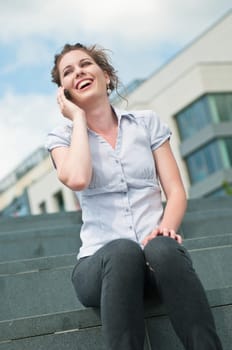 Young beautiful laughing woman calling with mobile phone
