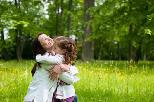 Small girl enjoying life with her mother outdoors