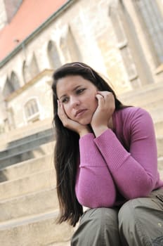 Portrait of young worried woman (teenage girl) in depression - church in background