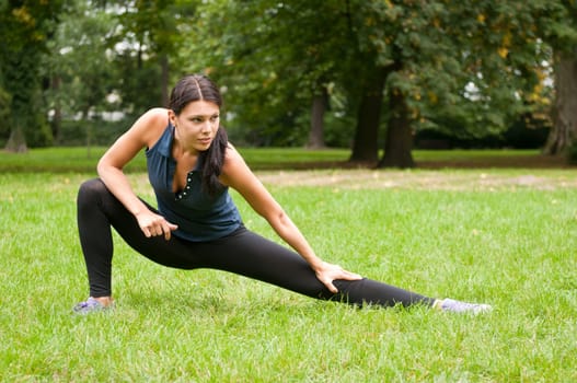 Woman performs stretching before sport in park