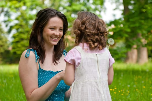Small girl enjoying life with her mother outdoors