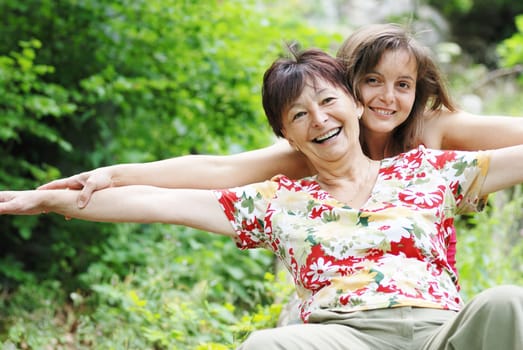 Mature woman has happy time with her daughter in nature