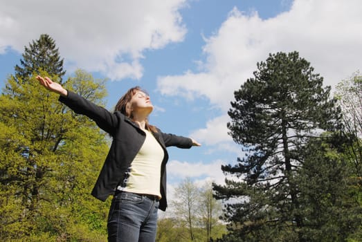Woman is  enjoying her life outdoors among trees on sun