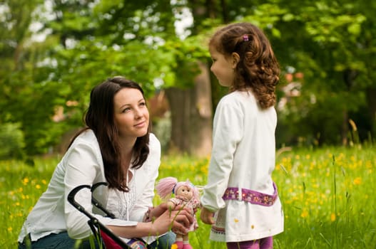Mother spending time with her cute girl outside in park - nostalgy mood