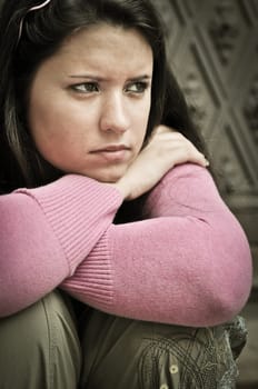 Portrait of young worried woman (teenage girl) in depression outdoors