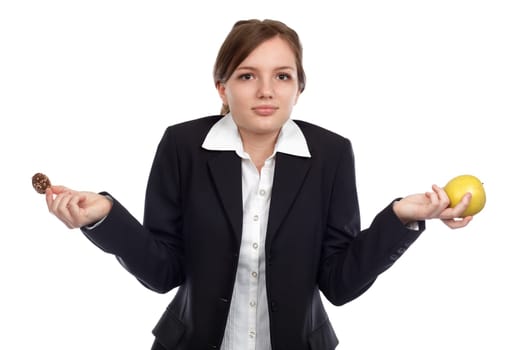 Young woman undecided what to choose between apple and chocolate cookies