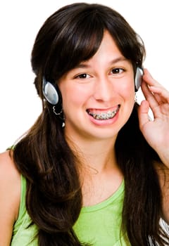 Teenage girl wearing headphones and listening to music isolated over white