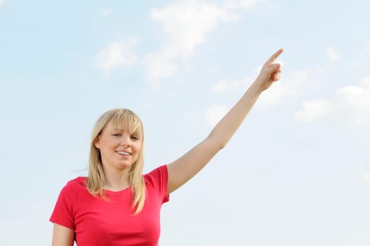 Young woman pointing at the sky