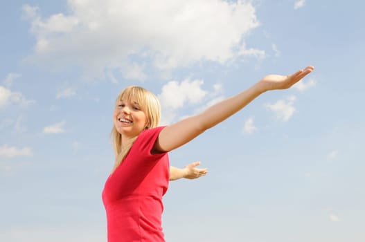 Happy young woman spreads her arms