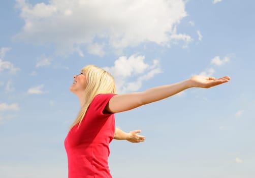 Happy young woman spreads her arms