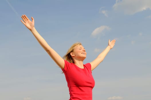 Happy young woman spreads her arms