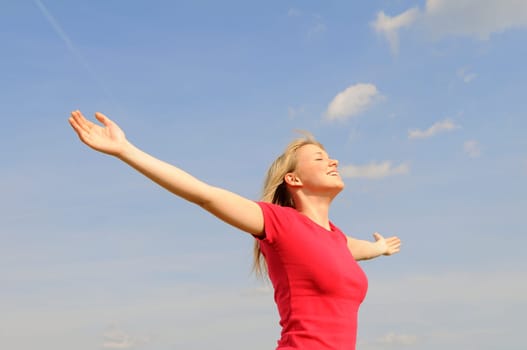 Happy young woman spreads her arms
