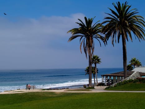 Park on a beach north of San Diego, California, with a couple resting on a bench.