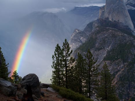 A rainbow in the fog beside half dome in Yosemite National Park, California.