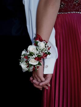 White rose wrist corsage with red ribbon and babies breath.