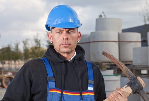 Construction worker in blue hard hat standing outdoors at construction site