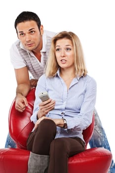 Young pretty woman and handsome man watching TV together  isolated on white