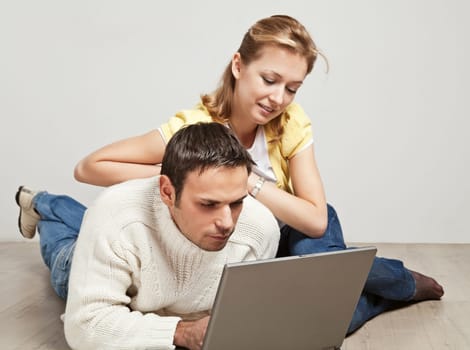 Happy young man and woman sitting together and looking at computer screen