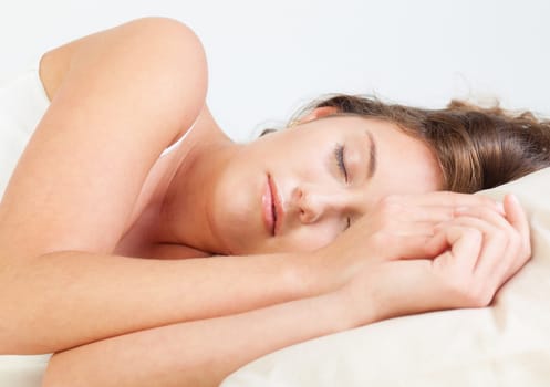 Pretty young woman sleeps in her bed