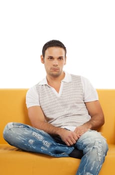 Young handsome man watches TV sitting on yellow leather sofa