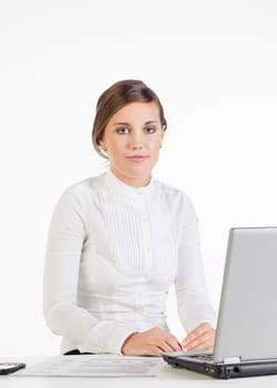 Smiling young businesswoman sitting at her workplace