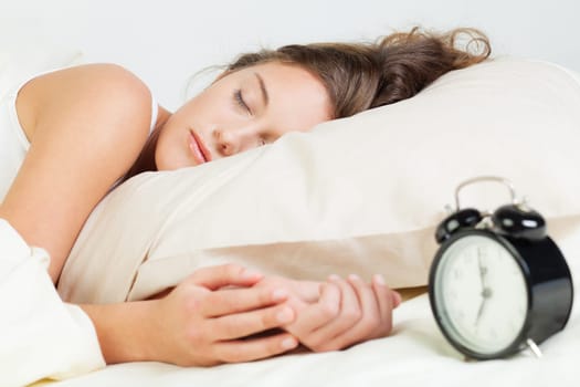 Pretty young woman sleeps in her bed