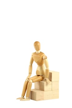 A Wooden manikin sitting on blocks