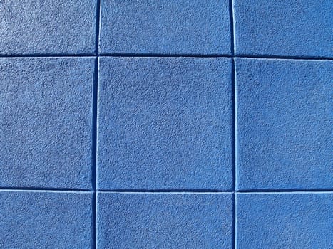 Blue exterior concrete block wall in a tic-tac-toe pattern.