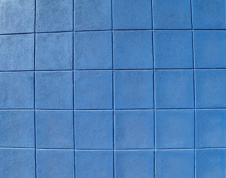 Blue concrete block exterior wall styled in rows of squares.