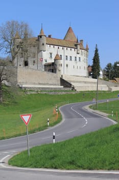Road leading to Old castle of Oron by beautiful weather, Oron-le-Chatel, Vaud canton, Switzerland, next to a cut trunk. It was built in the XIIIrd century. The castle belonged to several private owners (1801 : Roberti family, 1870 : Adolphe Gaiffe) and wa