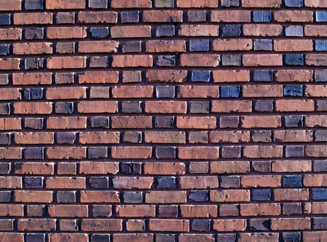 Multi-colored and duo-sized, old exterior brick wall.