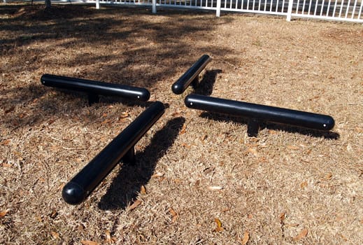 Black log hop exercise equipment in a park.