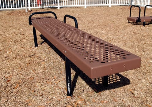 Brown and black body stretch exercise equipment in a park.