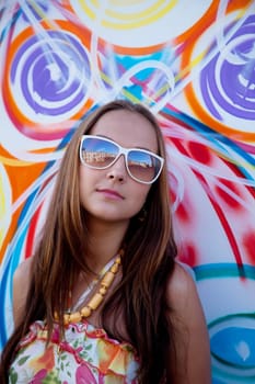 woman in glass stand near graffiti wall - summer day