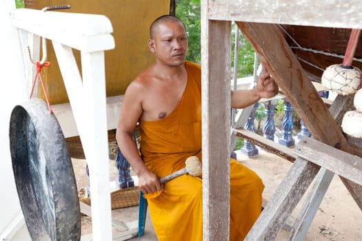 Buddhist monk doing spiritual drumming in the temple