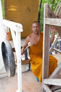 Buddhist monk doing spiritual drumming in the temple