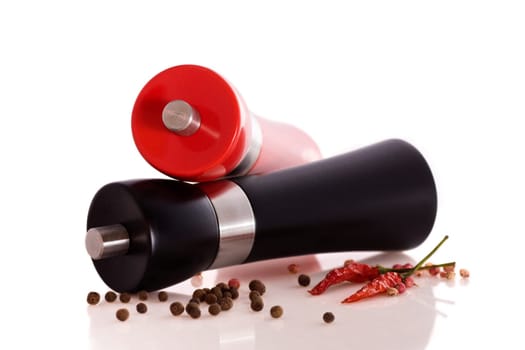 Large polished wooden, two pepper/salt mill with chilli on white background