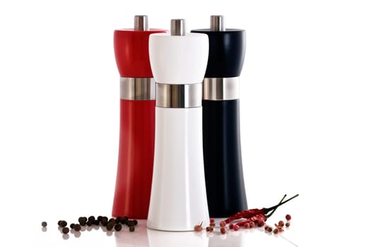 Large polished wooden, pepper/salt mill with chilli on white background