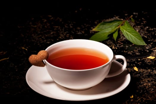 mug of tea with a saucer and sugar heat on black background