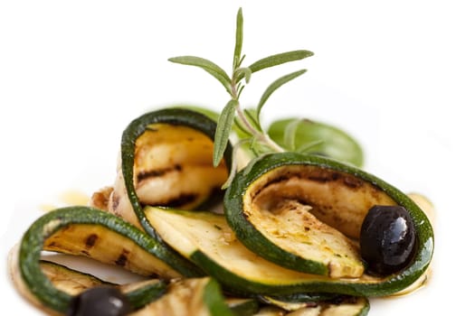 Grilled zucchini rolled up with olive in olive oil