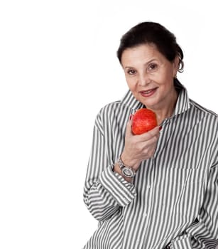 Close-up of mature woman smiling with an red apple against white background