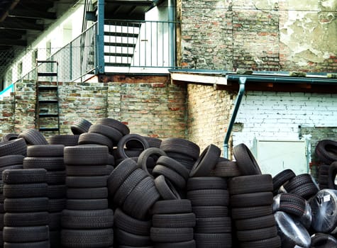 Wall of old car tires with old Brick Wall in the background